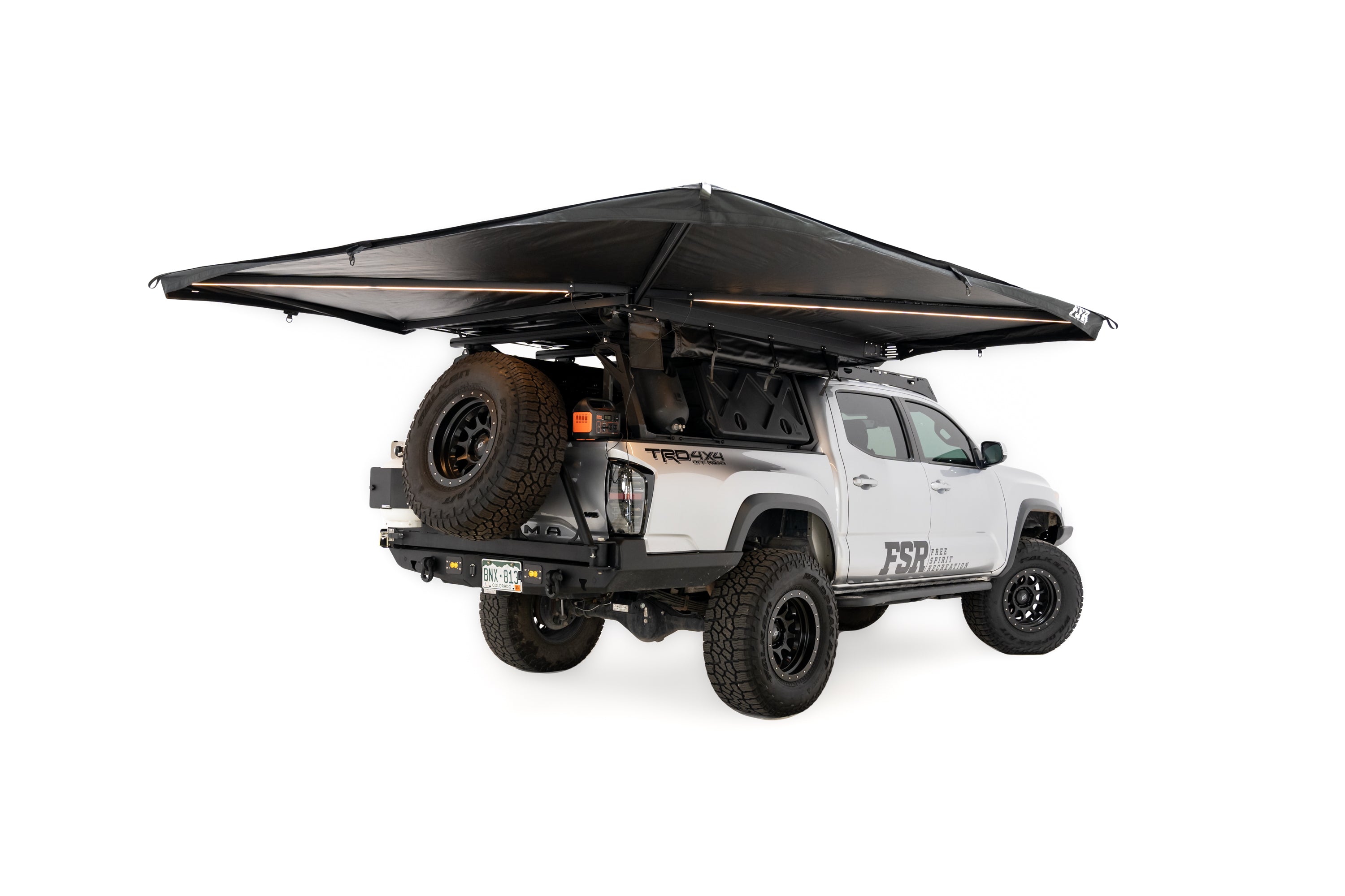 Photo of deployed 270 V2 Awning by Freespirit Recreation with integrated lighting displayed on a Toyota Tacoma pickup in white cyc.
