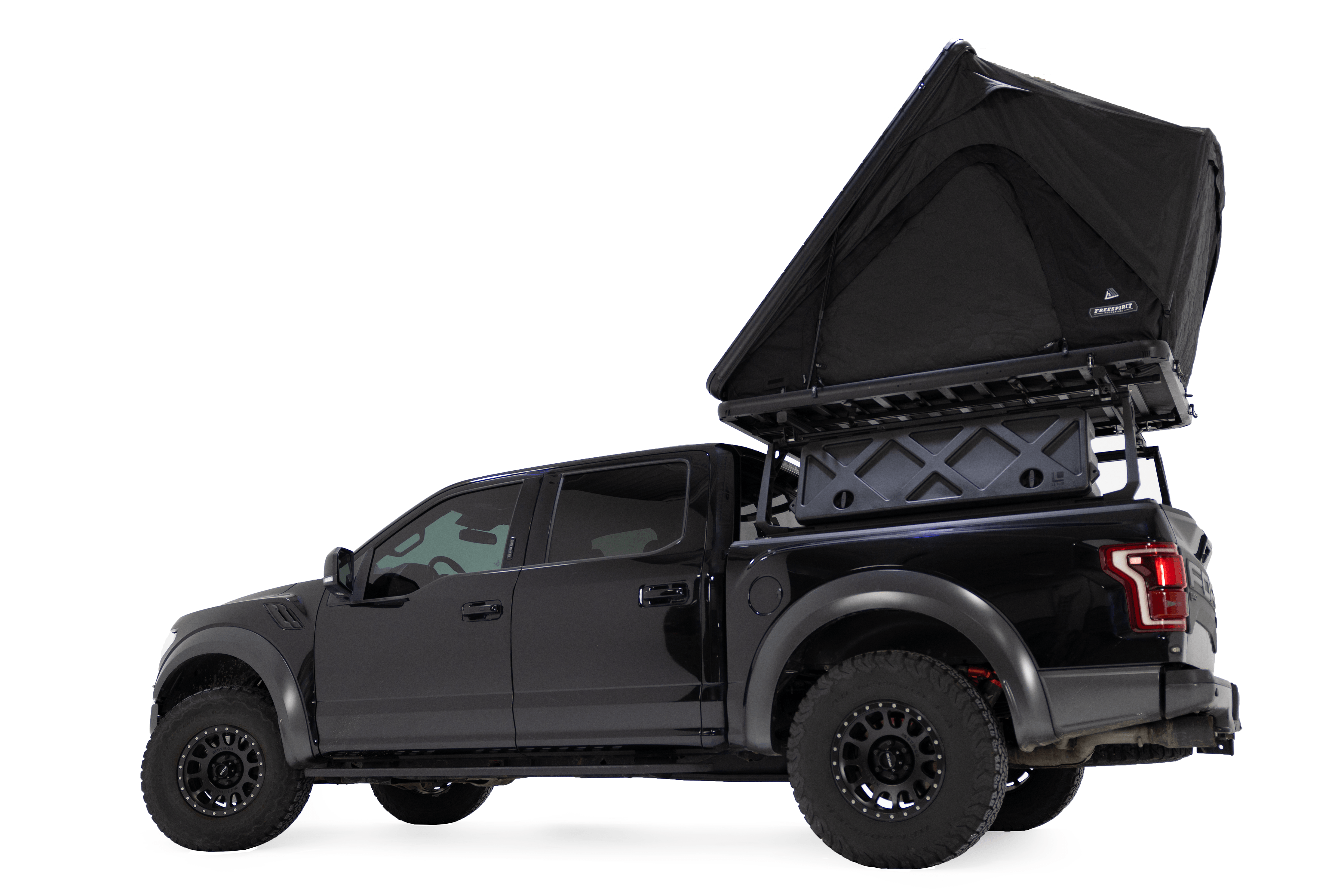 Lower angle photo of the Aspen Lite XL - Rooftop Tent by Freespirit Recreation deployed on a black Ford Raptor.