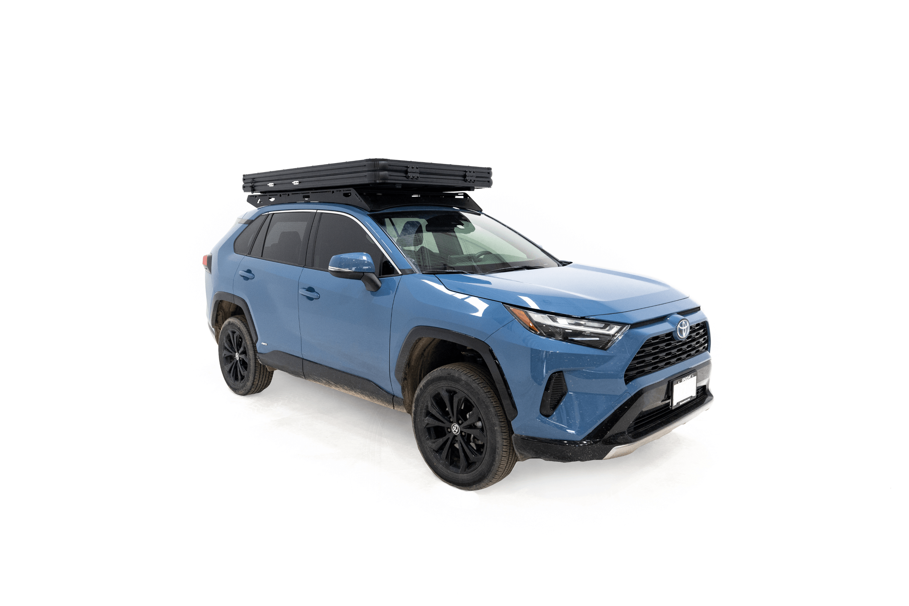 Photo of Aspen Lite Standard - Rooftop Tent by Freespirit Recreation closed and mounted on a blue Toyota Rav4