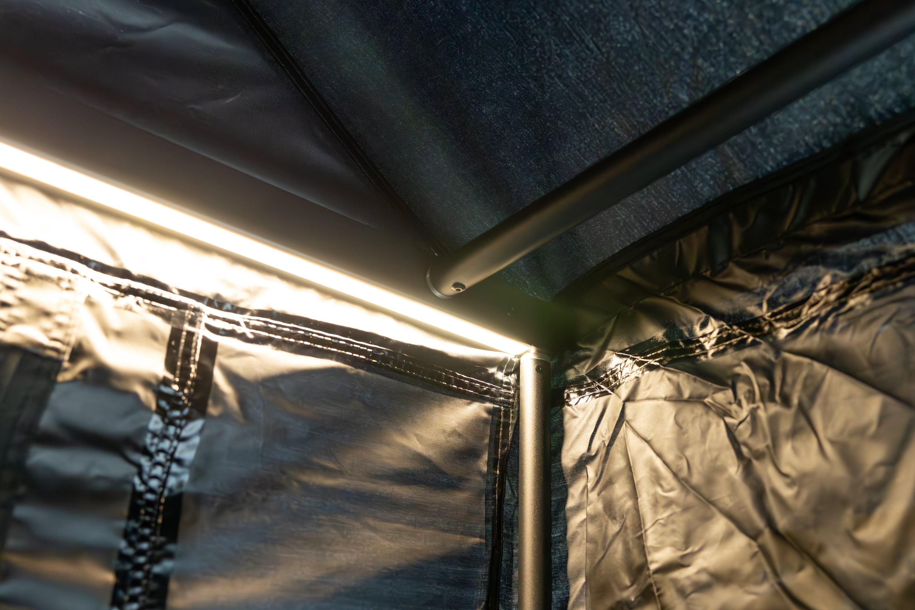 A second interior photo of the interior arm of Awn-X Annex room displaying the support poles and LED light on the opposite side.