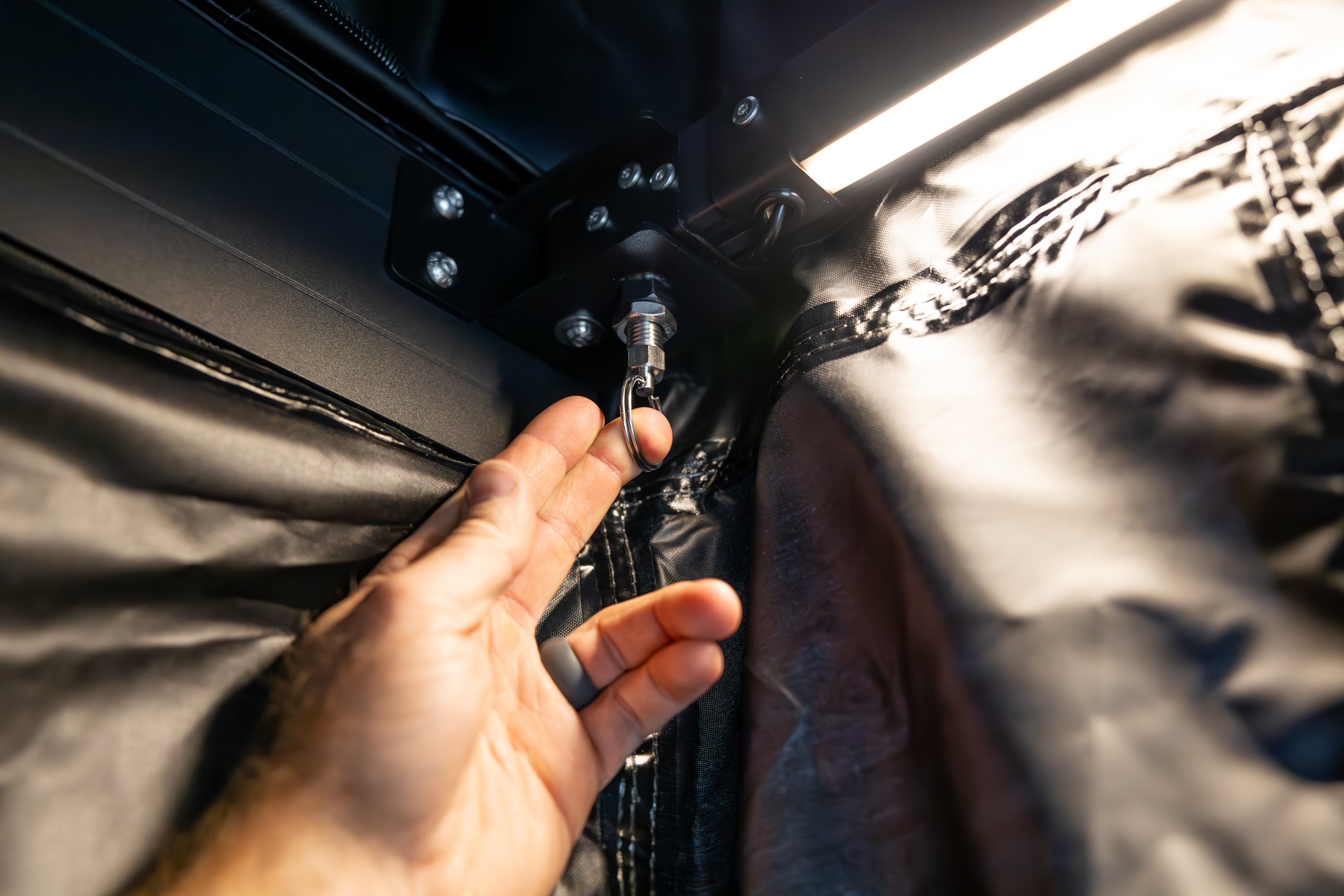Photo of the locking pull pins in use by person's hand up close.