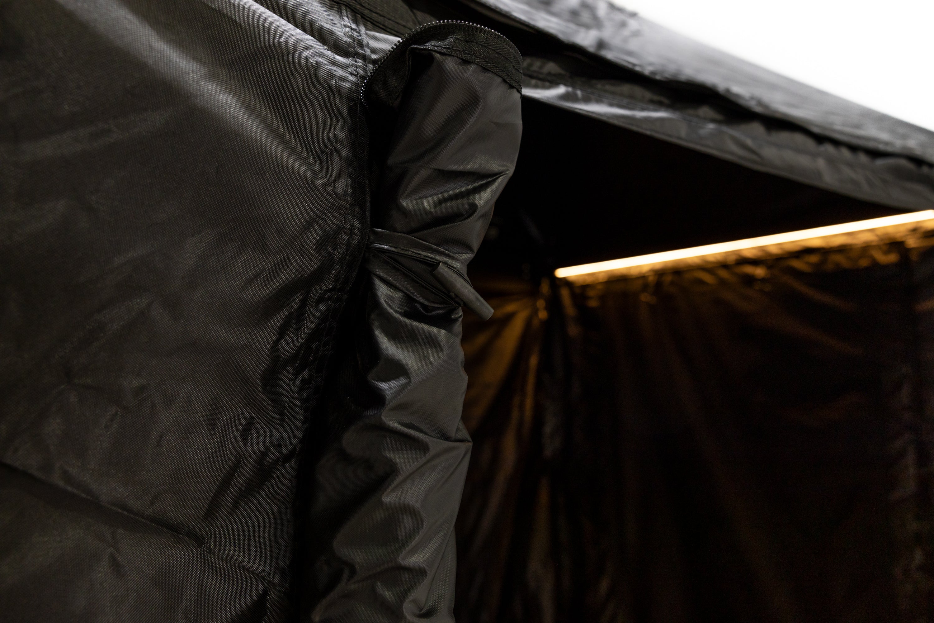 Up close photo of the roll-away door secured with loop and peg design on the front of the Awn-X annex room.