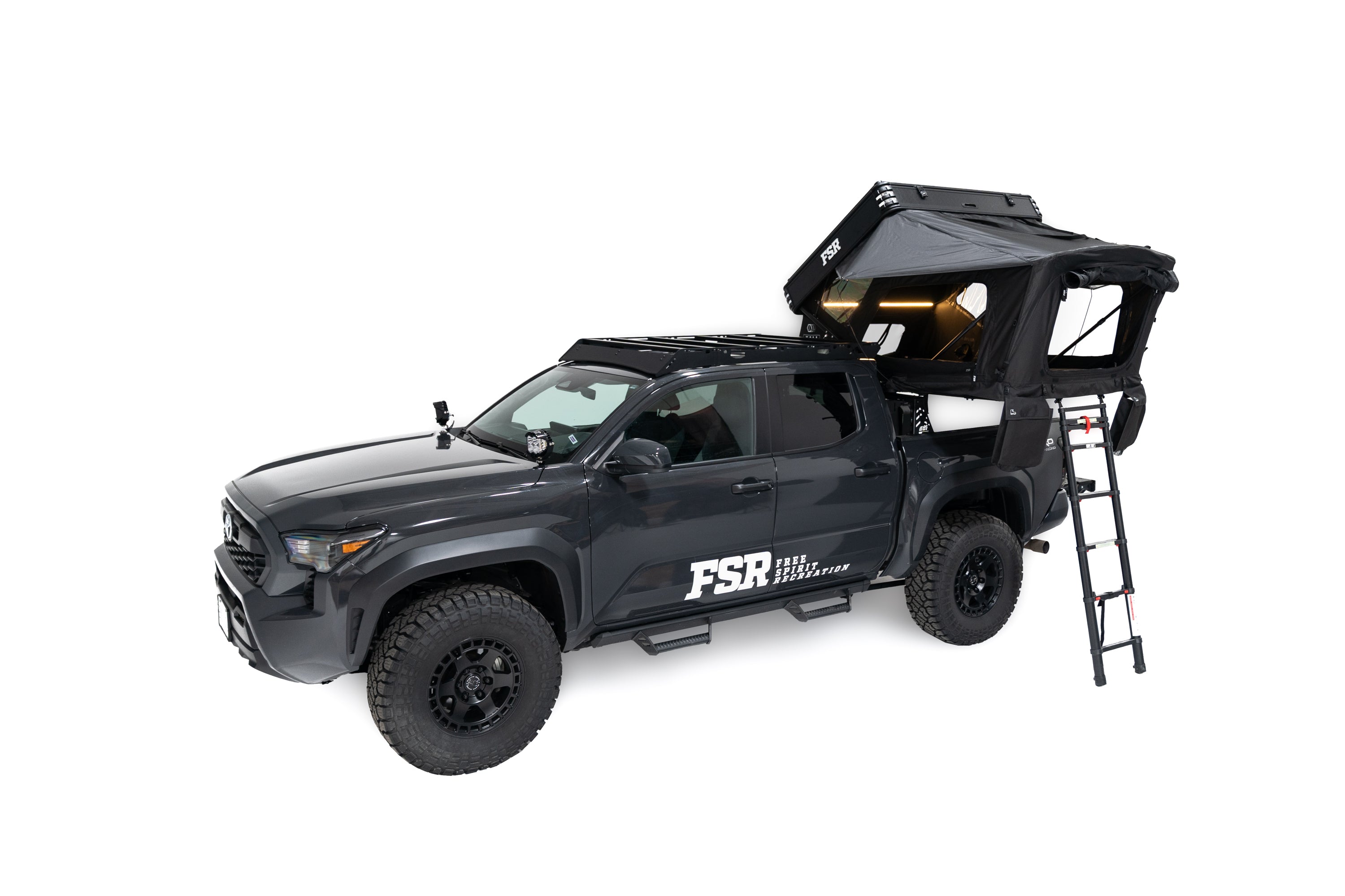 Top down Exterior Photo of Kali hardshell rooftop tent by FSR - Deployed on the truck bed of a 4th gen Toyota Tacoma with lights on and windows open.