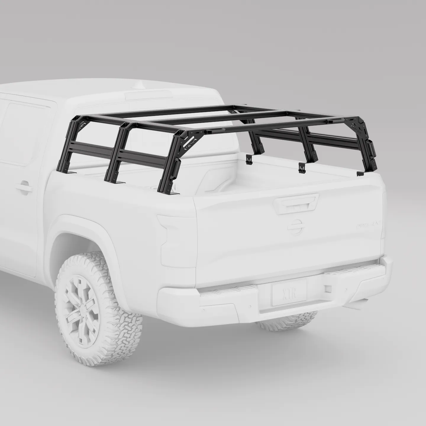 White nissan frontier truck with a black xtrusion bed rack on a gray background