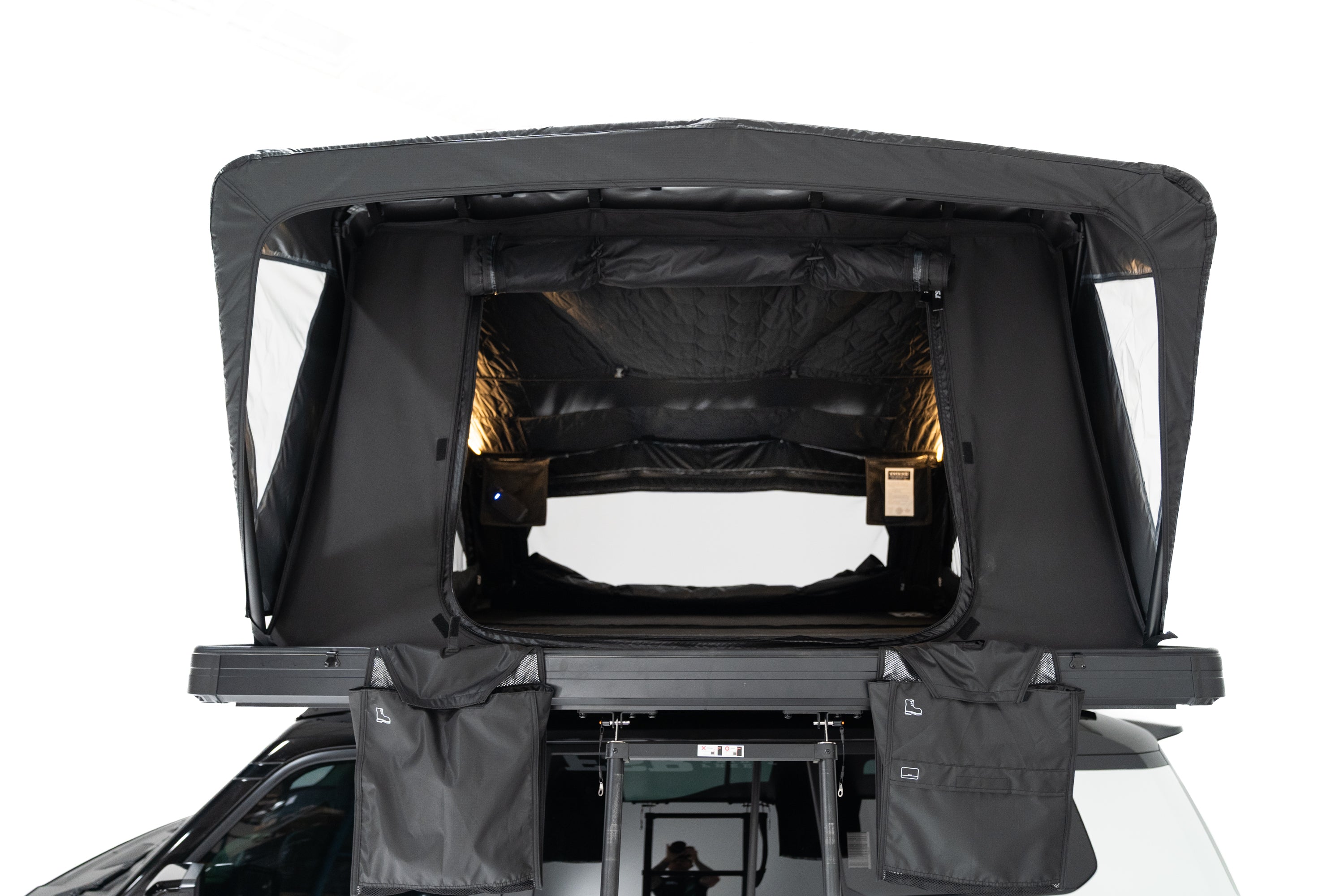 Front angle Close up Exterior photo of the Nova King rooftop tent mounted on a white Toyota land cruiser with the tent windows open and lights on.