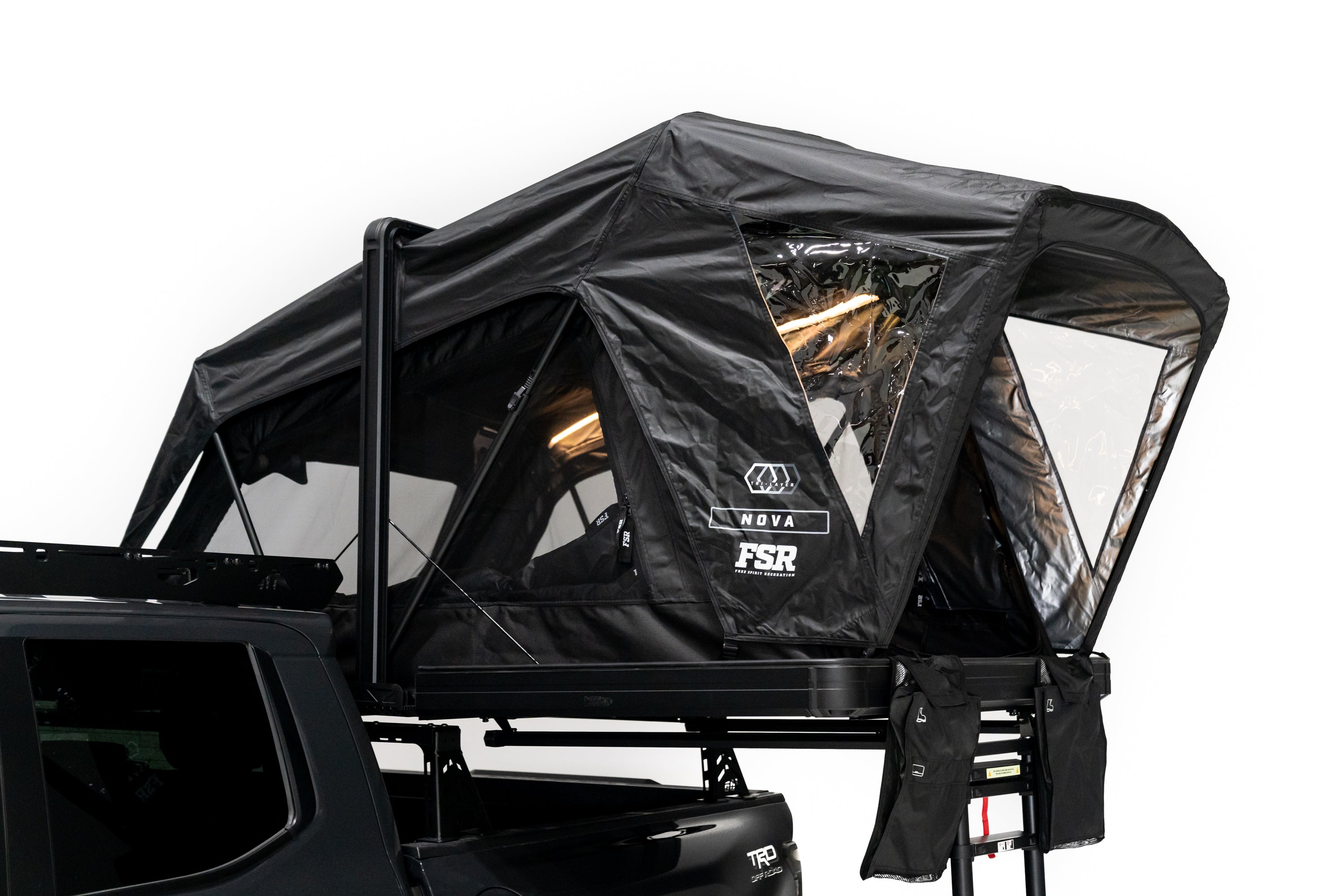 Close up photo of Nova Hybrid rooftop tent deployed on the rear of a 2025 Toyota Tacoma with the interior lights on.