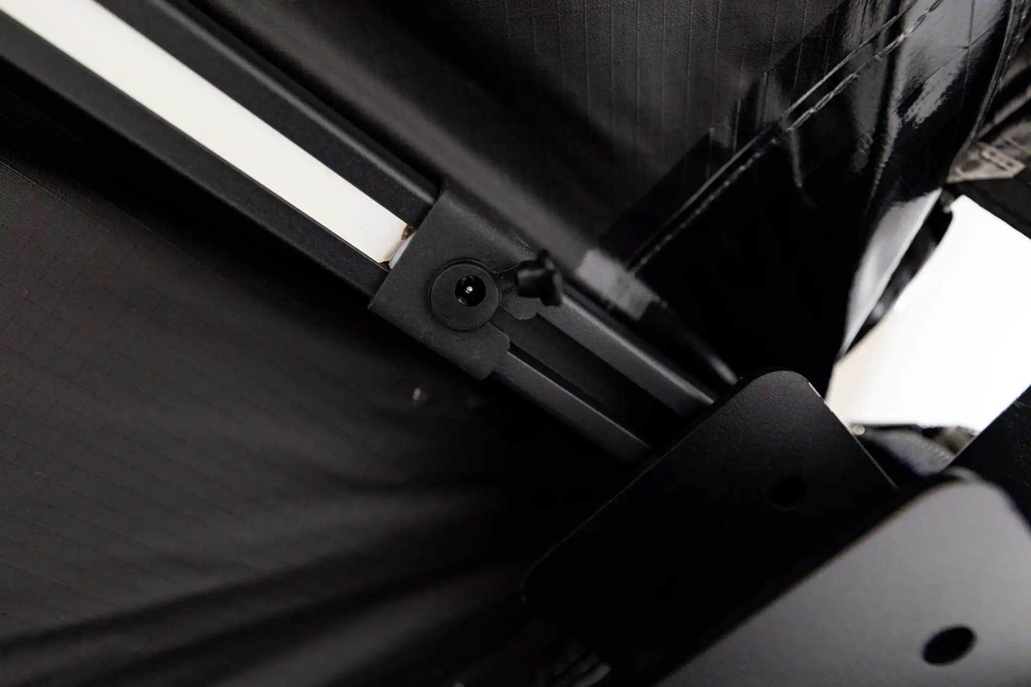 Close-up of the FSR 180 Degree Awning arms, hinge mechanism, and LED light plug