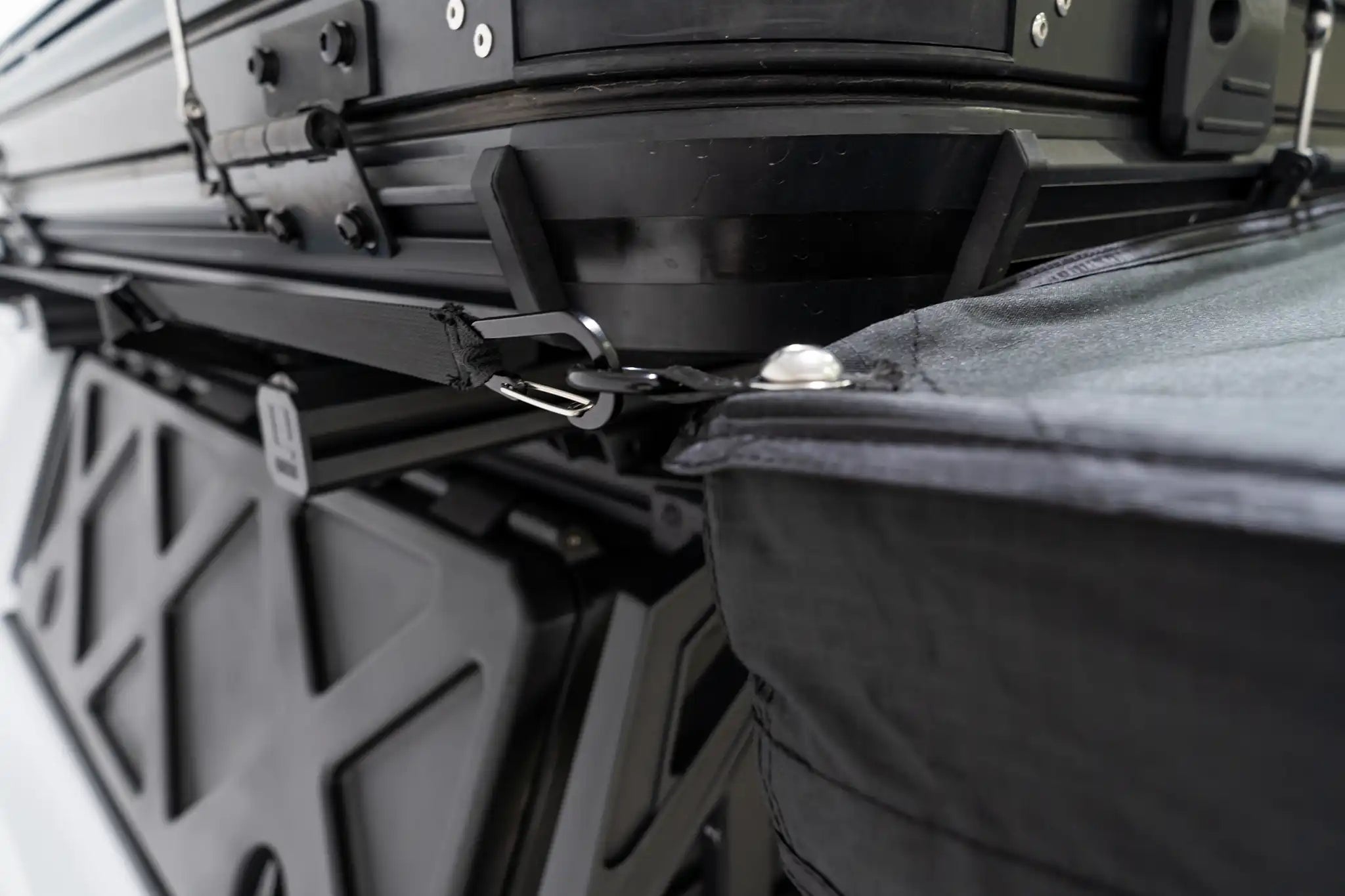 Close up photo of the carabiner attachment point and tensioning system on the FSR 270 degree Awning by Freespirit Recreation secured to the side of an FSR roof top tent.