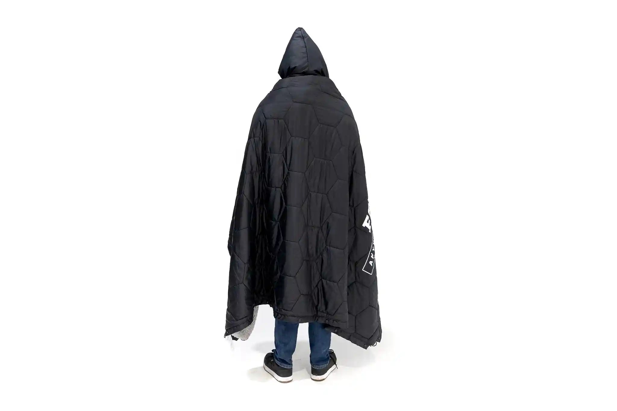 Back of a Person wearing the FSR Anywhere Camping Poncho Blanket showing the black quilted weather-resistant fabric shell