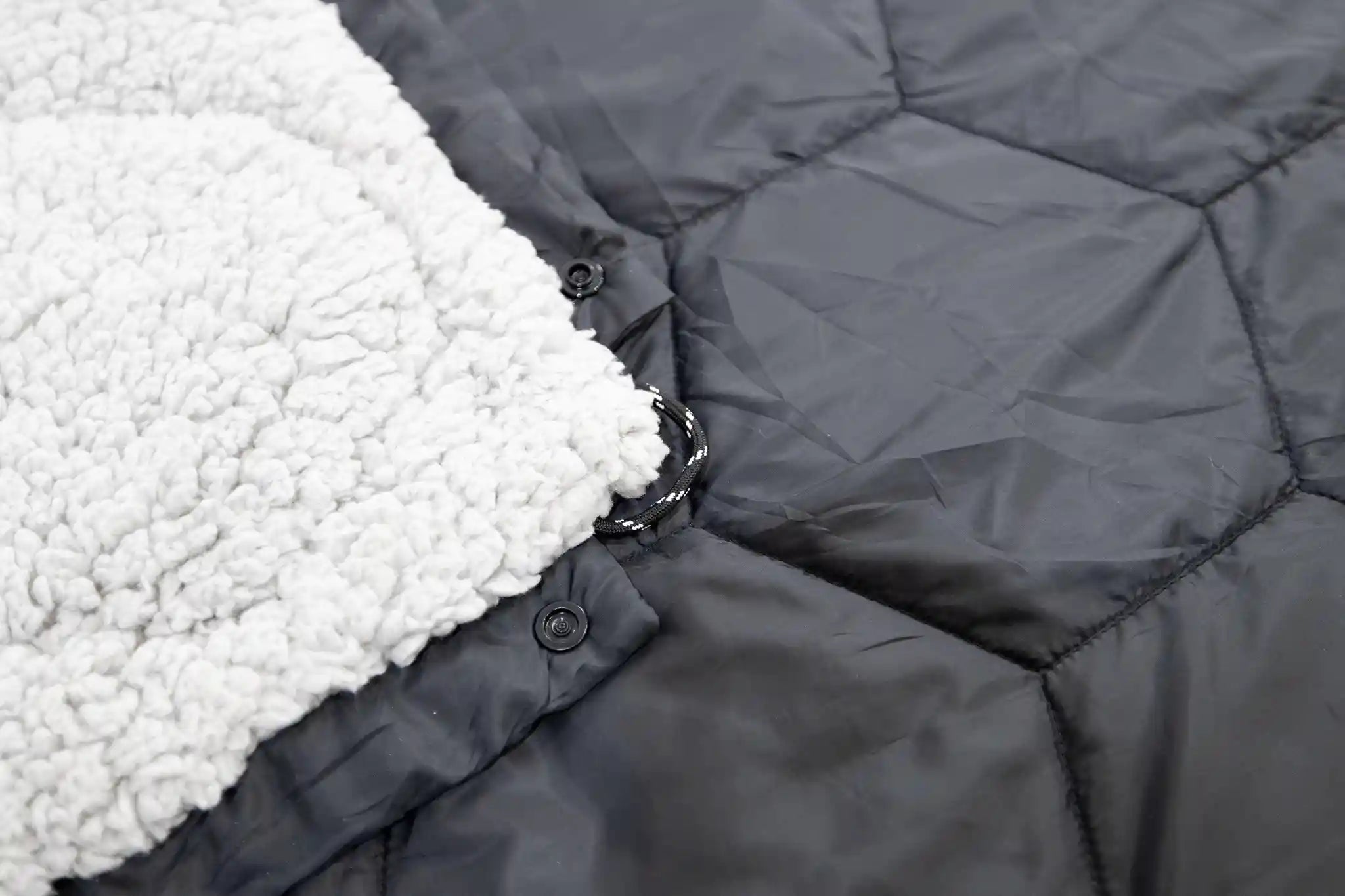 Close-up of the quilted white sherpa lining in the FSR Anywhere Poncho Camping Blanket