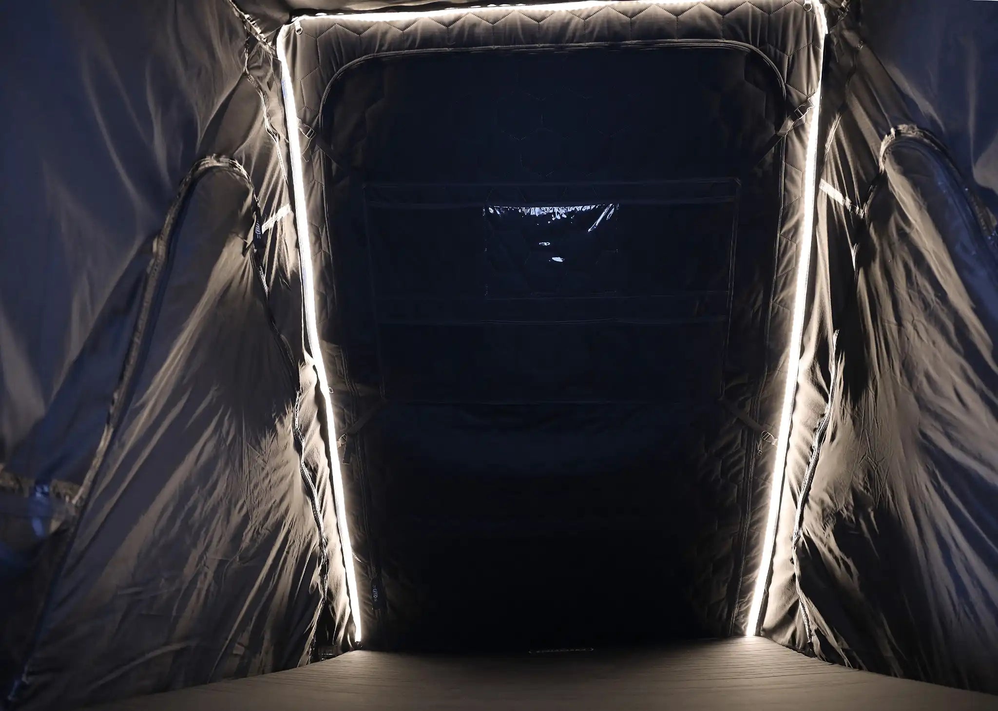 Photo of the interior of an FSR Aspen Lite Standard Rooftop Tent by Free Spirit Recreation with built-in dimmable LED lights illuminated