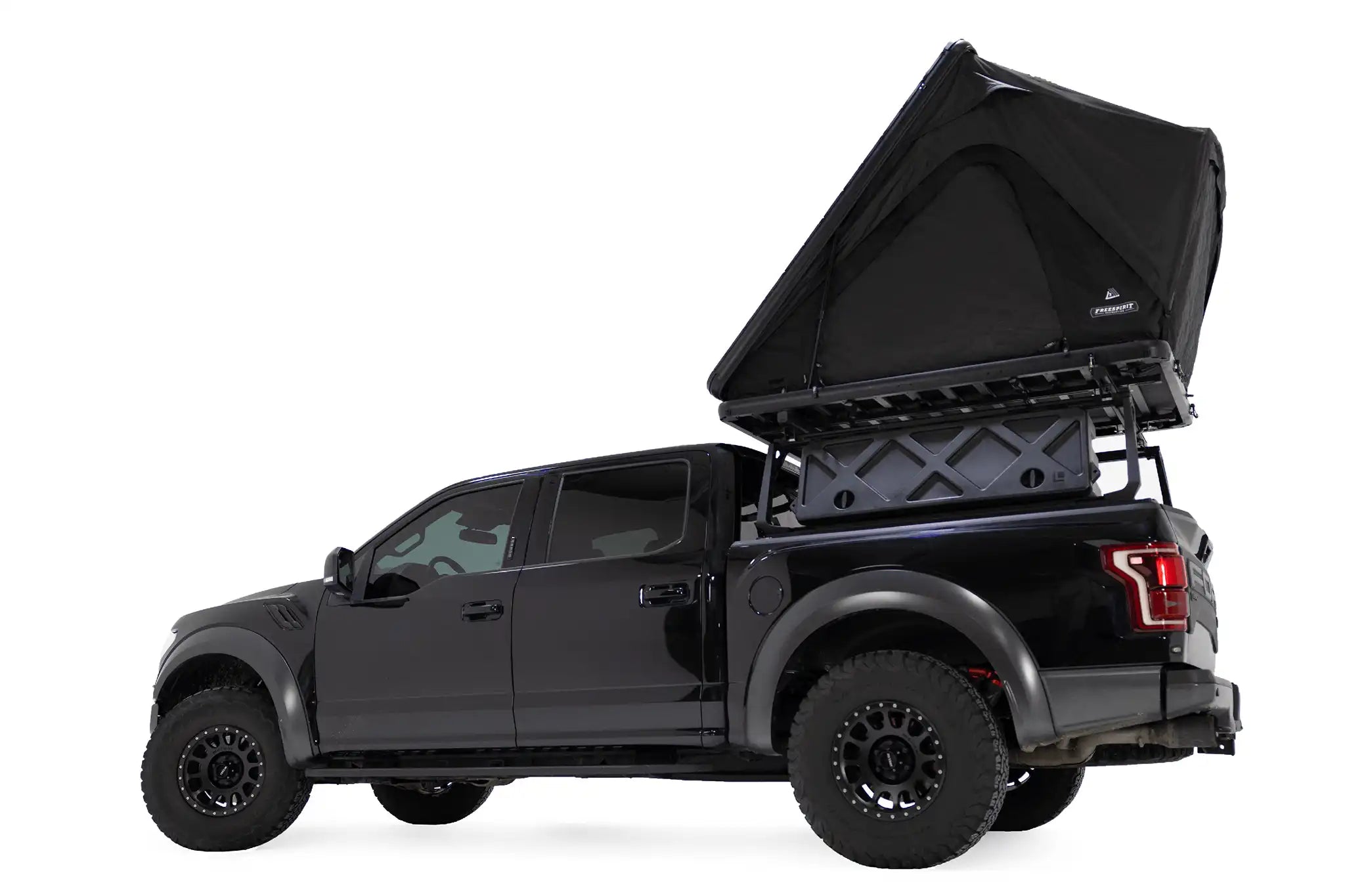 Lower angle photo of the FSR Aspen Lite XL Rooftop Tent by Free Spirit Recreation installed on a black Ford Raptor truck bed rack.