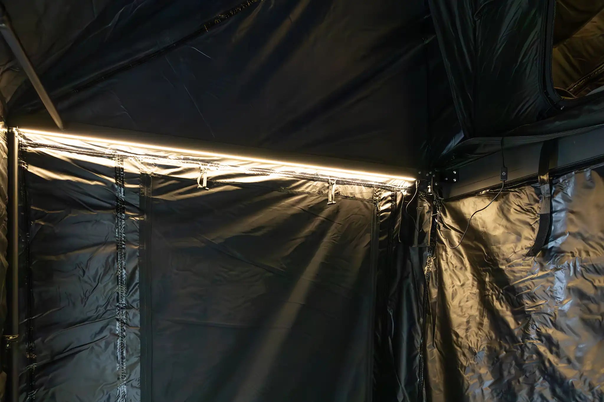 Wide shot of the interior of the FSR Double Shower Awning & Privacy Tent with dimmable LED lights illuminated