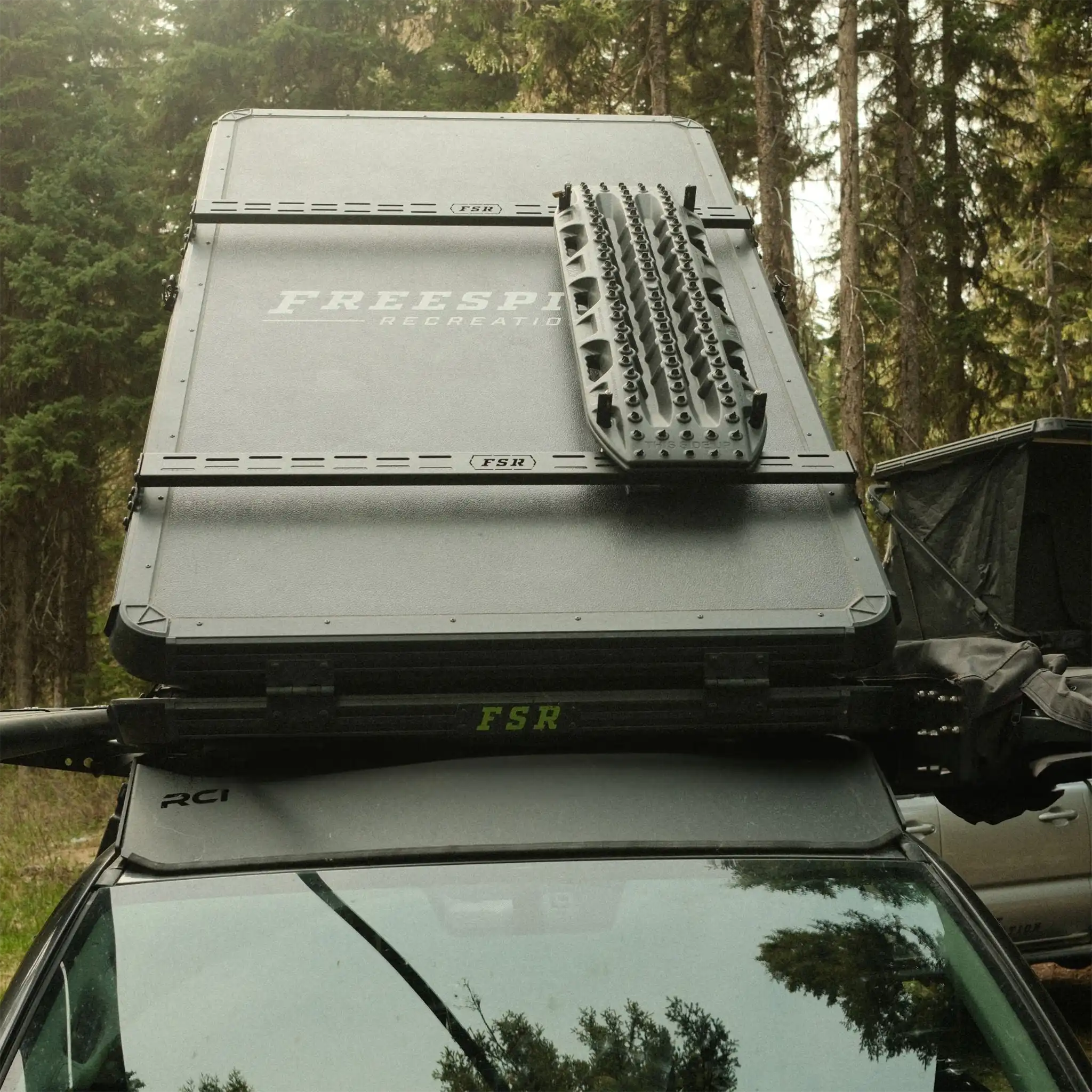 FSR Hardshell RTT Crossbars installed on a Freespirit Recreation hard shell roof top tent to carry cargo and off road traction boards on top of the rooftop tent.