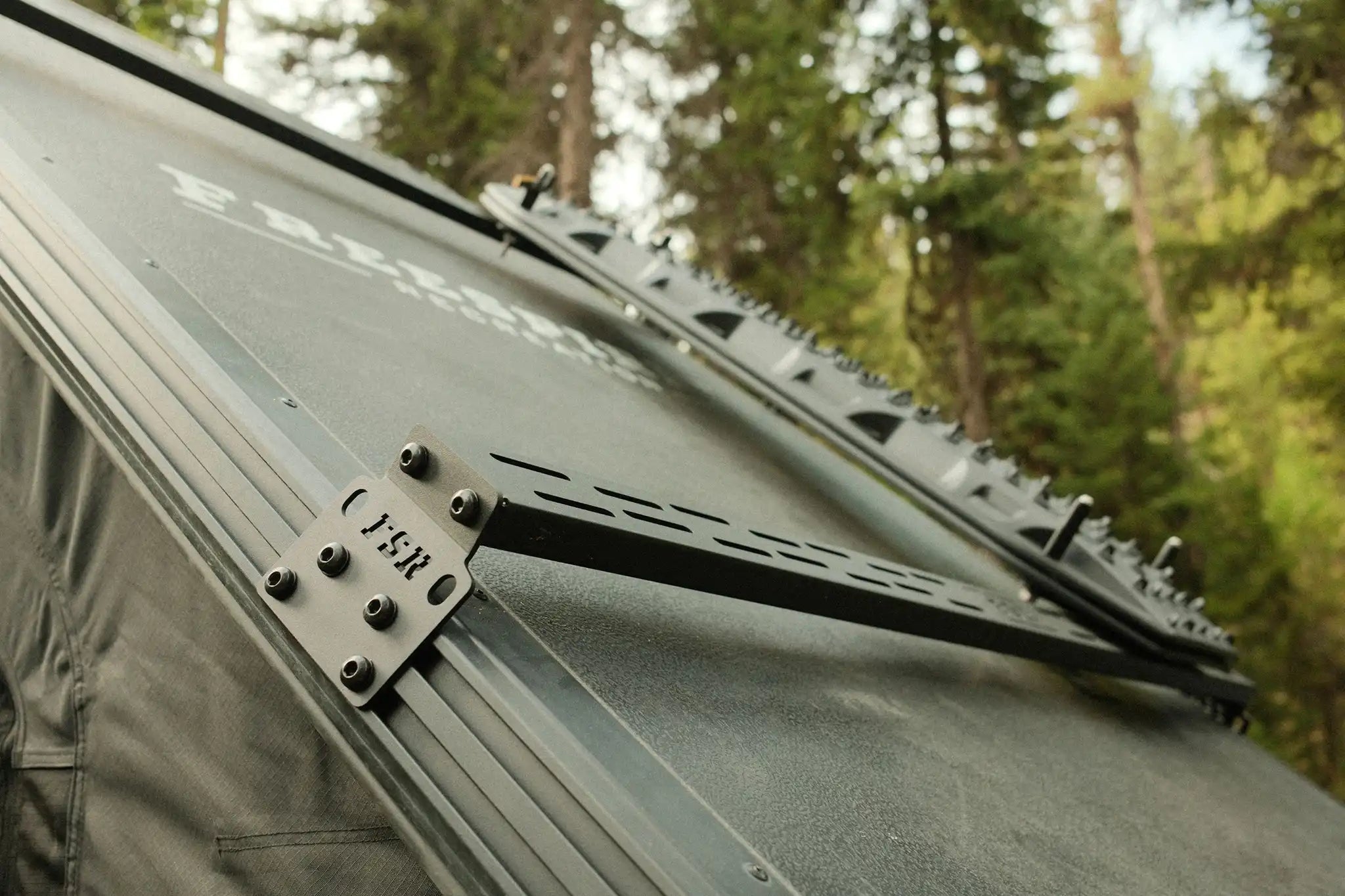 Close up of the mounting plates for the FSR Hardshell RTT Crossbars installed on a Freespirit Recreation hard shell roof top tent for cargo storage