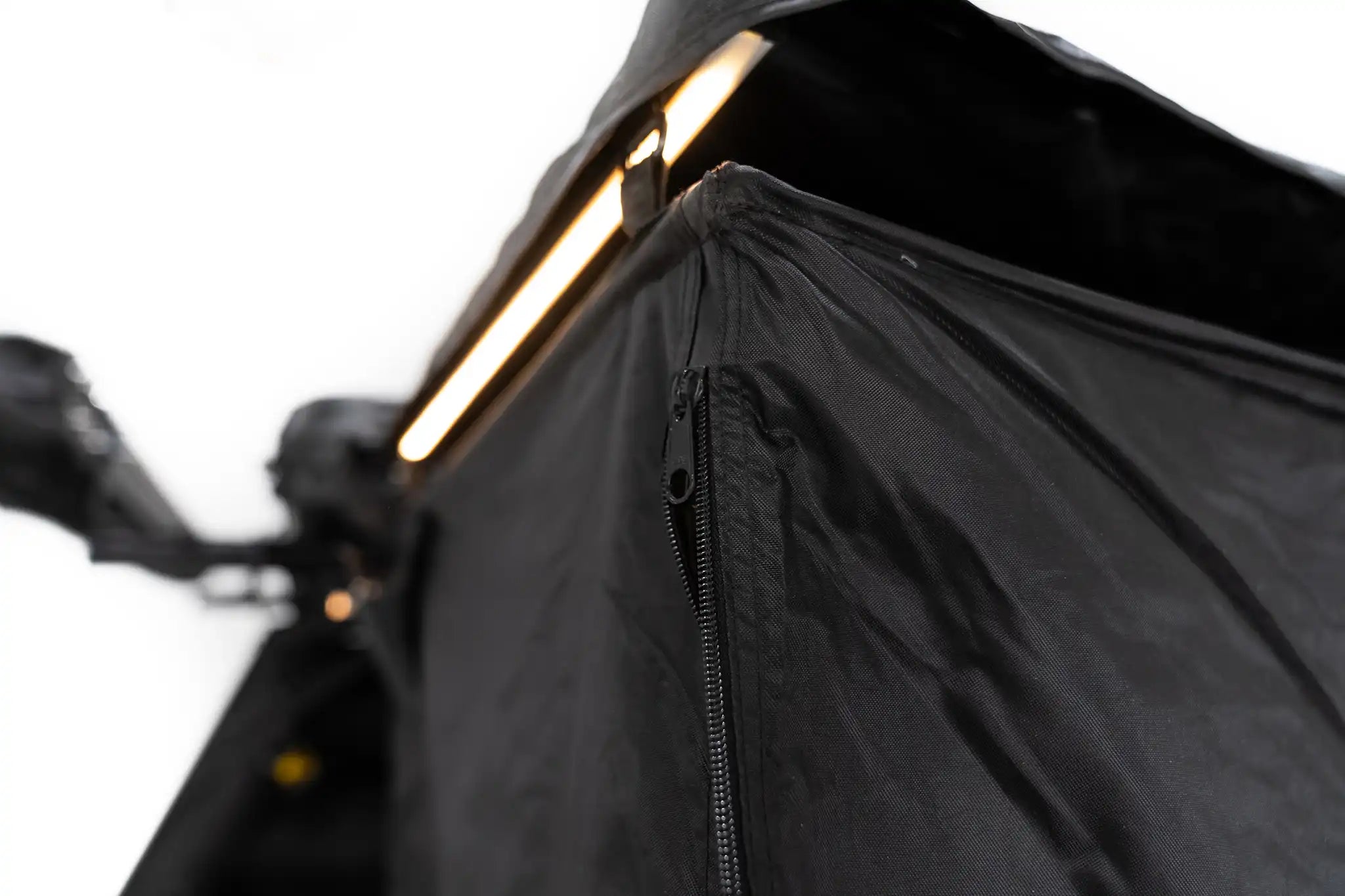 Close up image of the zipper on the FSR Shower Awning with built in LED light illuminated in the background