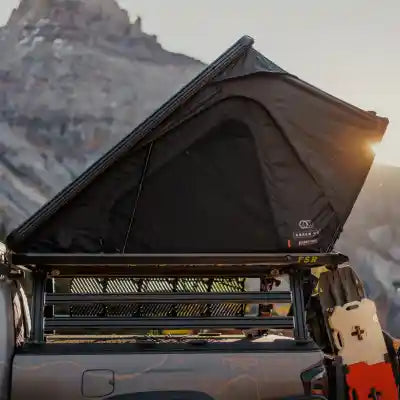 Image of a FSR Aspen Rooftop Tent installed on a vehicle while car camping with a mountain visible in the background