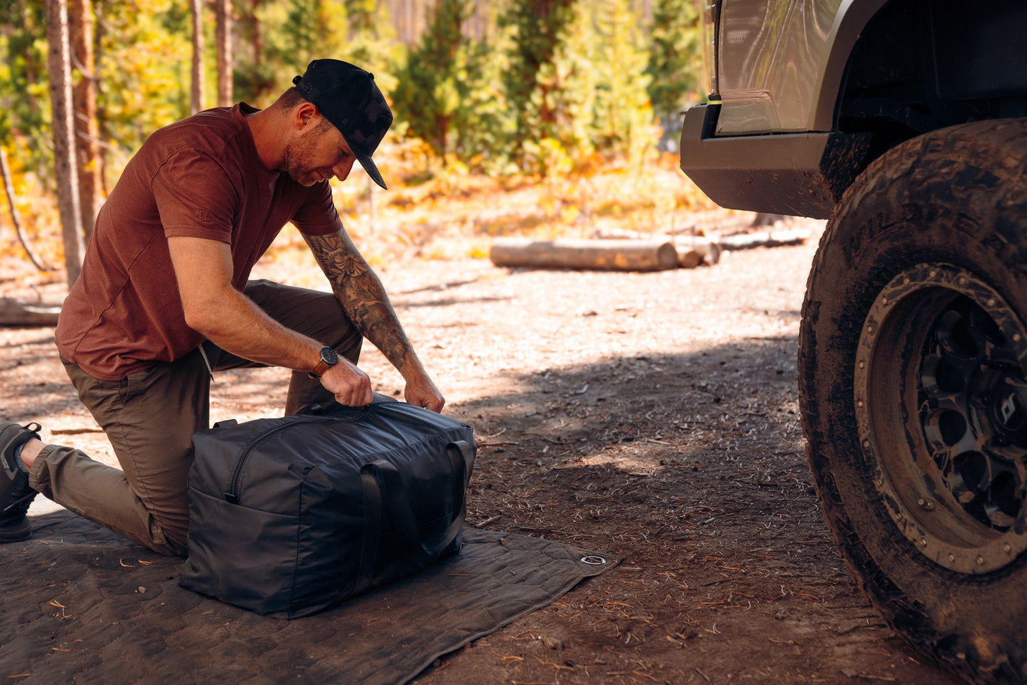 Man setting up FSR Awning walls & accessories at a wooded campsite