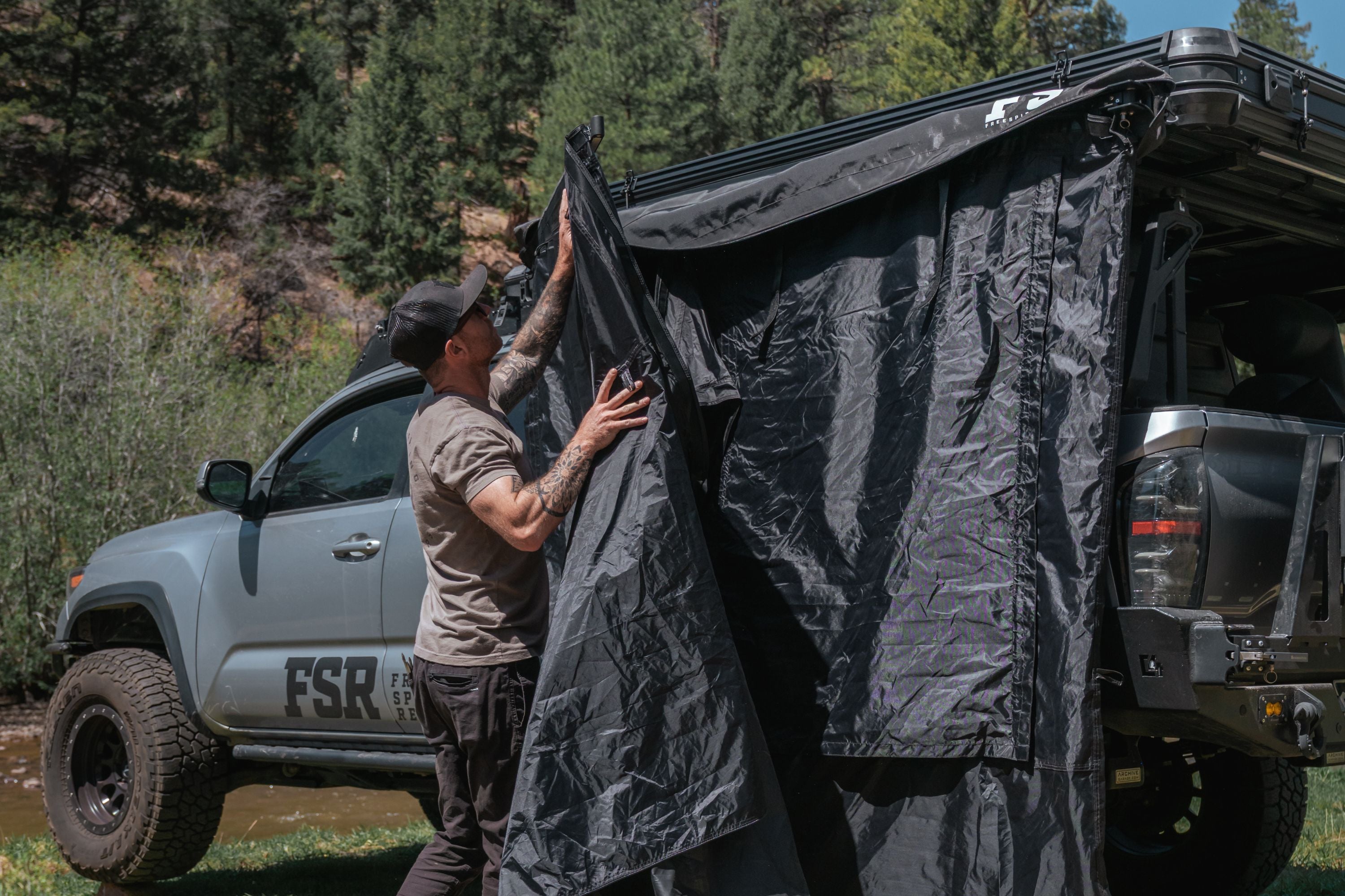 Picture of person camping using the new double shower/changing room on a toyota tacoma in the outdoors