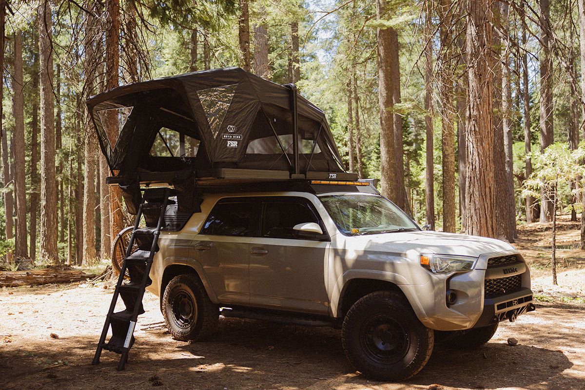 Silver Toyota 4Runner with roof rack in a forest with FSR Nova King Rooftop tent deployed.