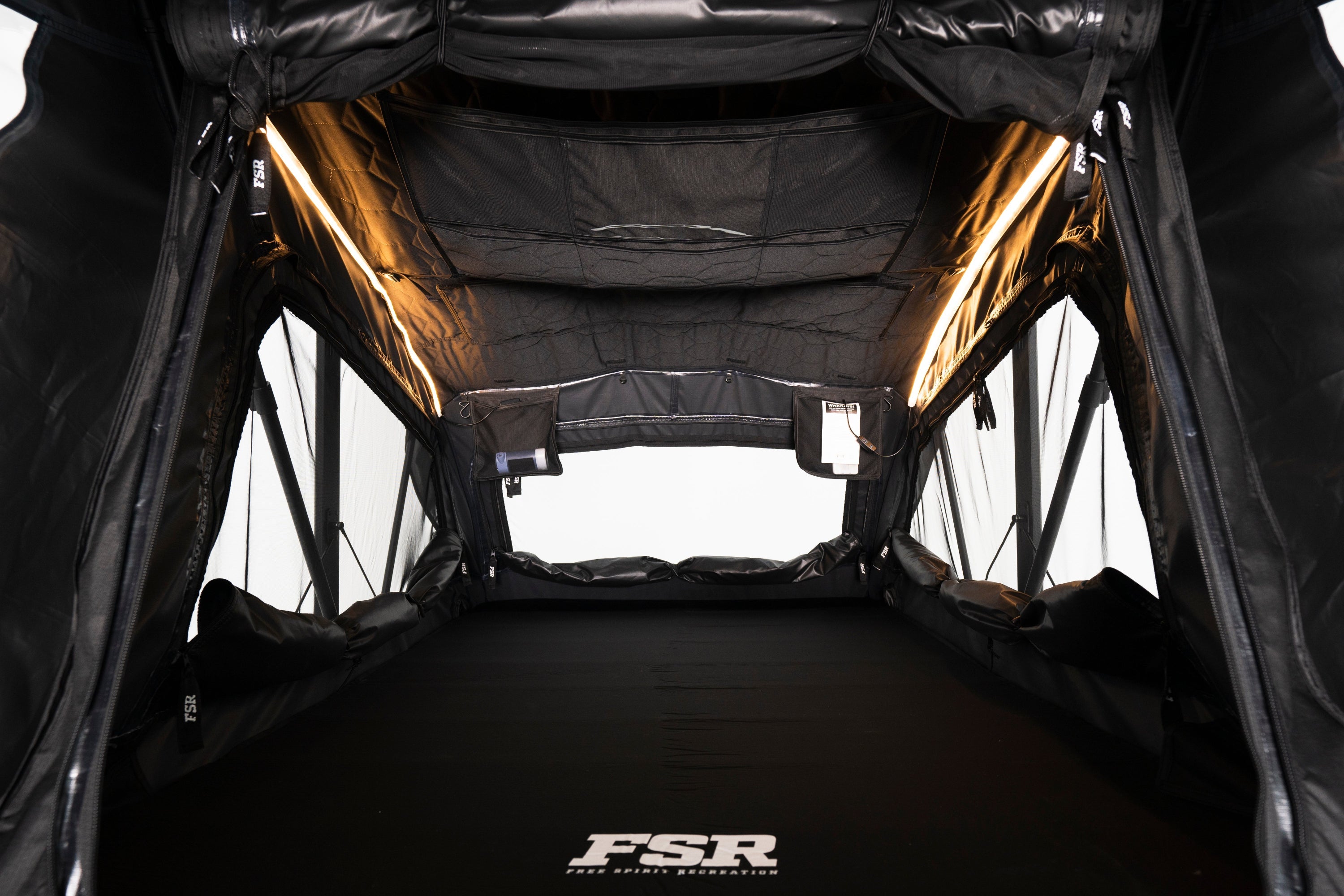 Interior Photo of Nova Hybrid rooftop tent deployed on the rear of a 2025 Toyota Tacoma with the lights on.