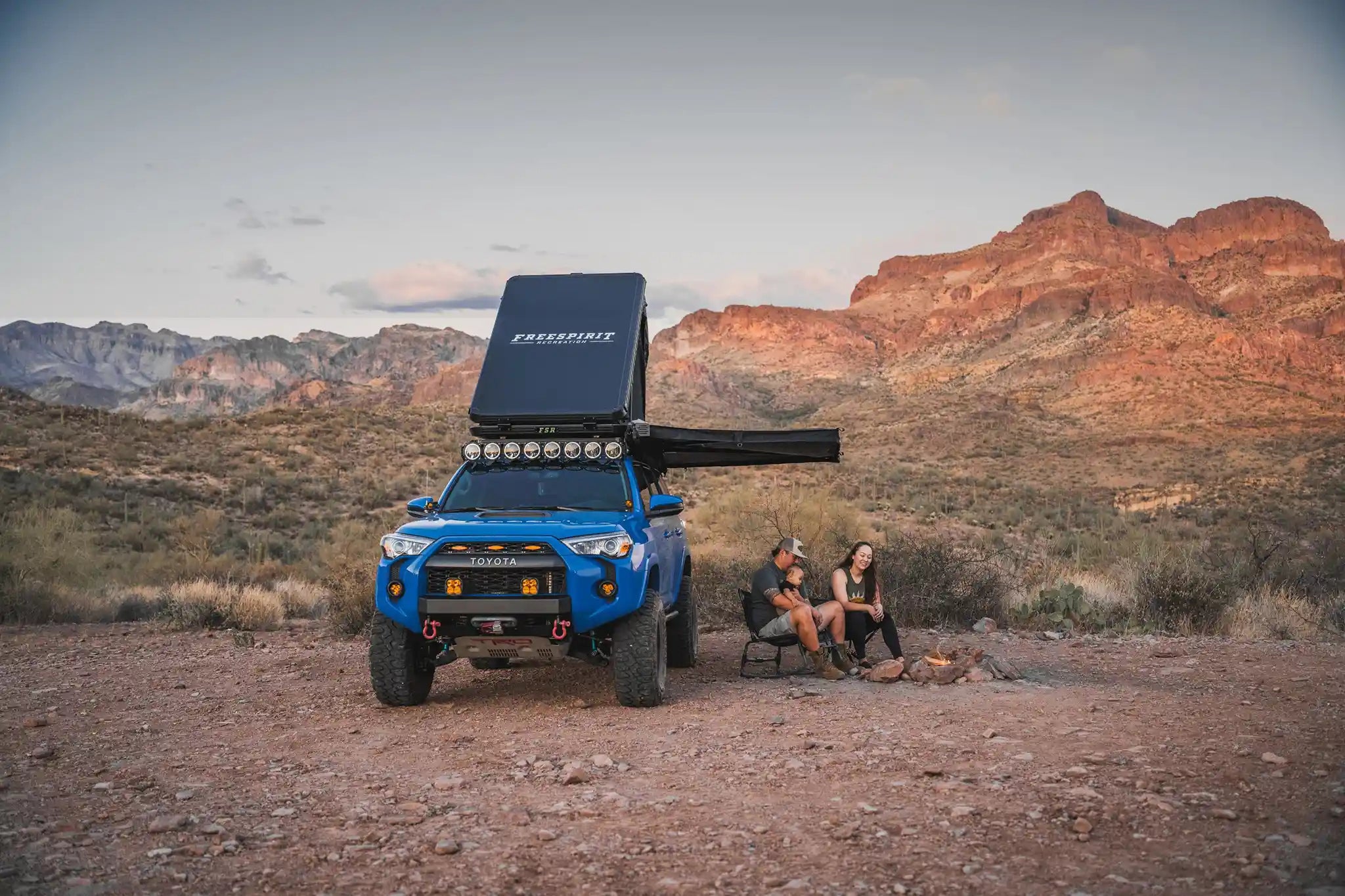 Blue Toyota 4Runner parked in the desert outfitted with Backwoods Adventure Mods Roof Rack with Free Spirit Recreation Rooftop Tent and 180 Awning included in the FSR 4Runner Adventure Bundle