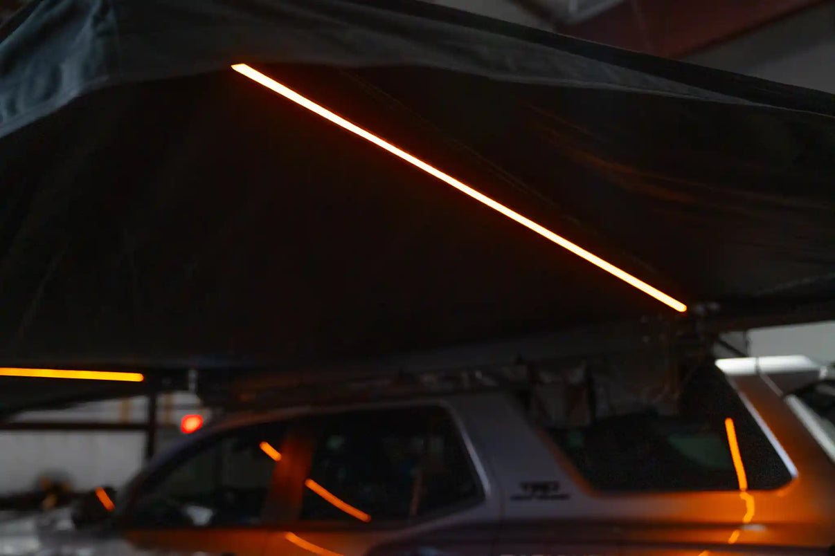 FSR 270 Awning from Free Spirit Recreation mounted to an overland SUV with built-in adjustable amber LED lights set to full brightness