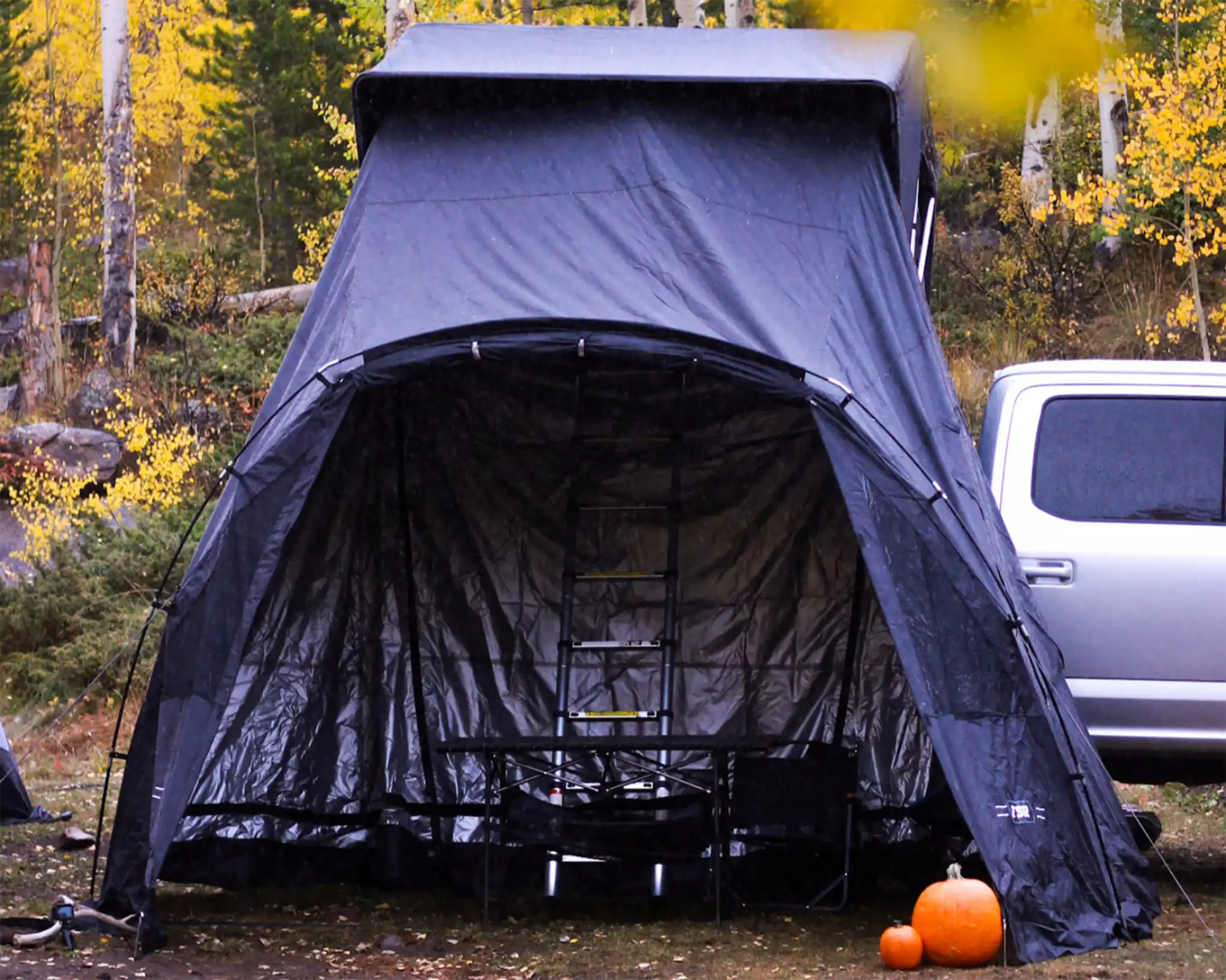 Early 2016 version of the FSR Rooftop Tent Awning from Free Spirit Recreation setup in a forested campsite in the fall