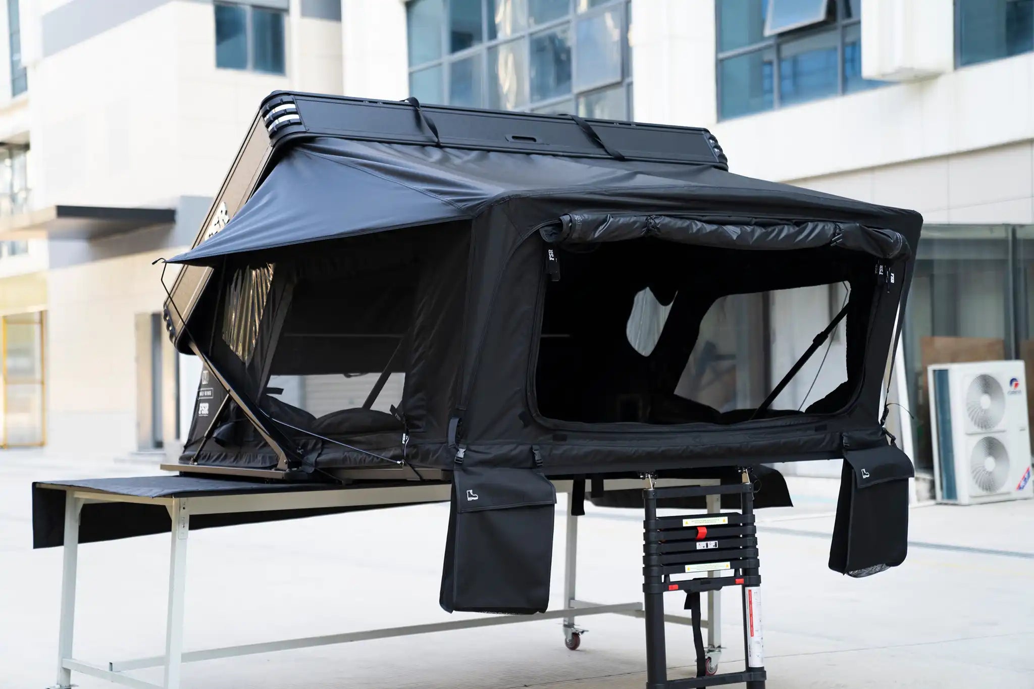 45 degree angle image of the side and front of the Kali King hard shell rooftop tent from Freespirit Recreation deployed with windows and door open