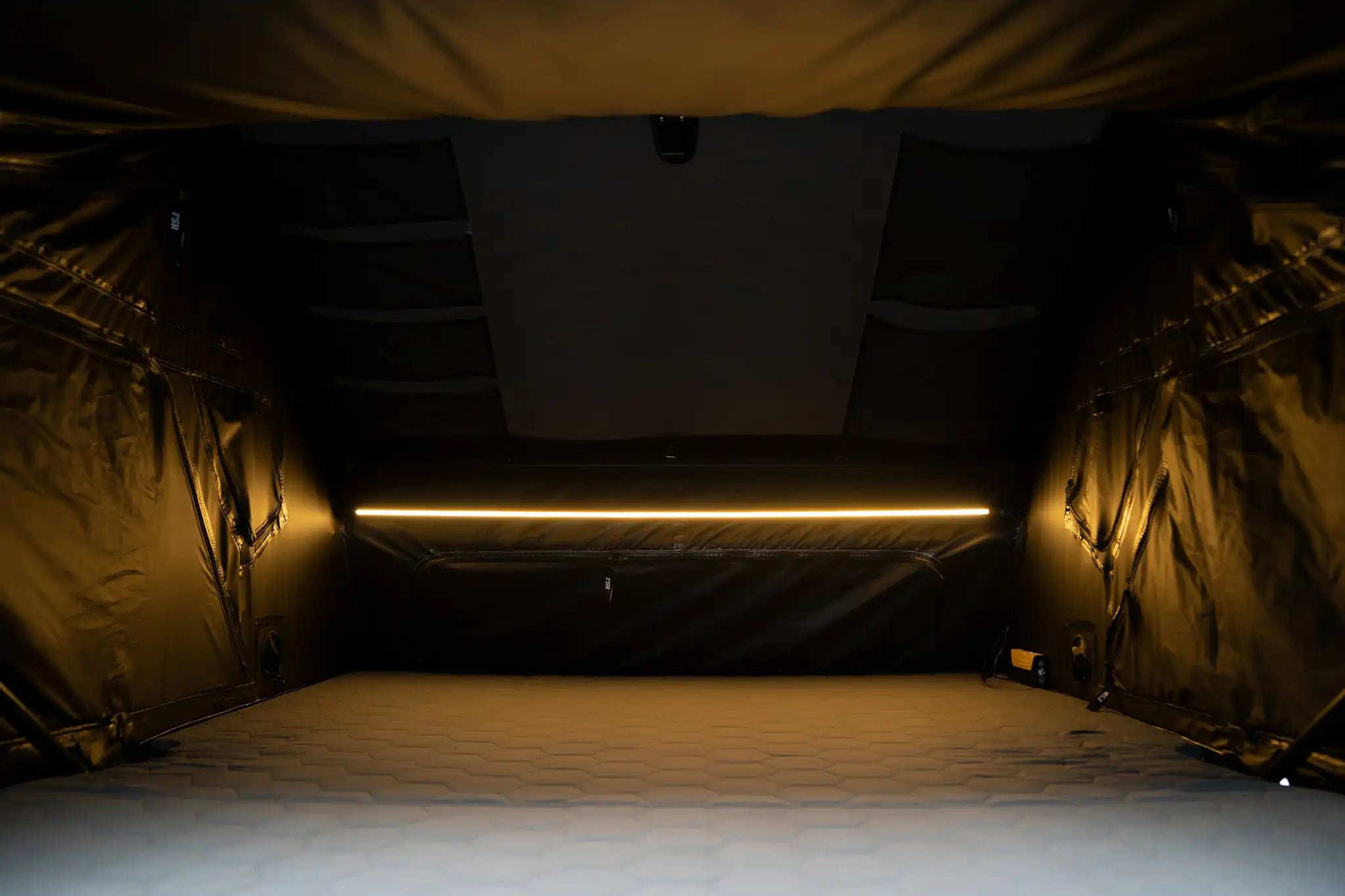 Image showing the interior of the FSR Kali King hard shell rooftop tent from Freespirit Recreation with windows closed and LED light illuminated.