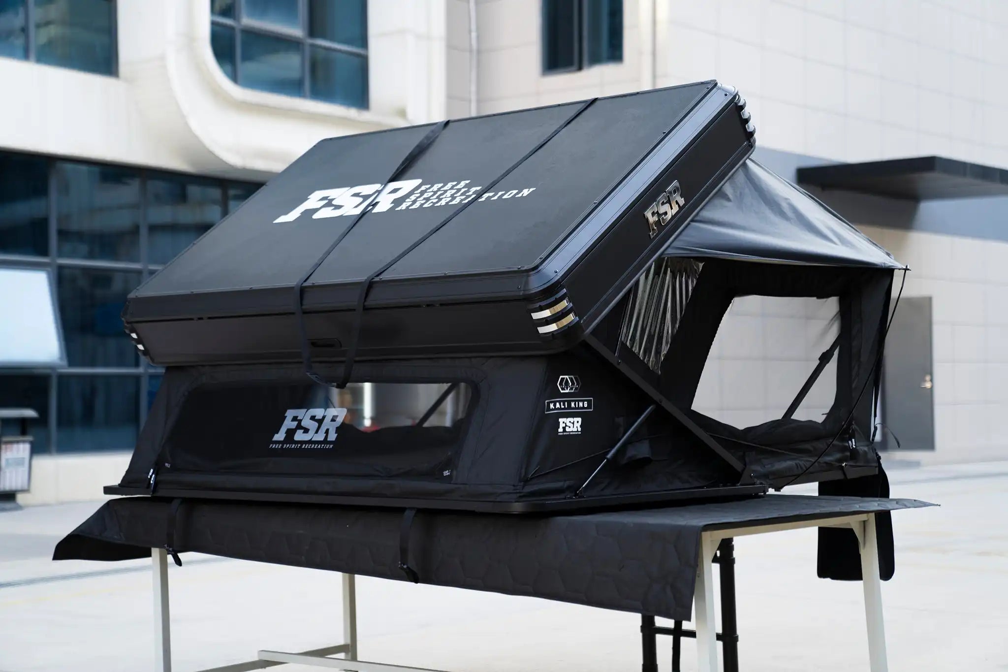 45 degree angle image of the back and left side of the Kali King hard shell rooftop tent from Freespirit Recreation deployed with windows and door open