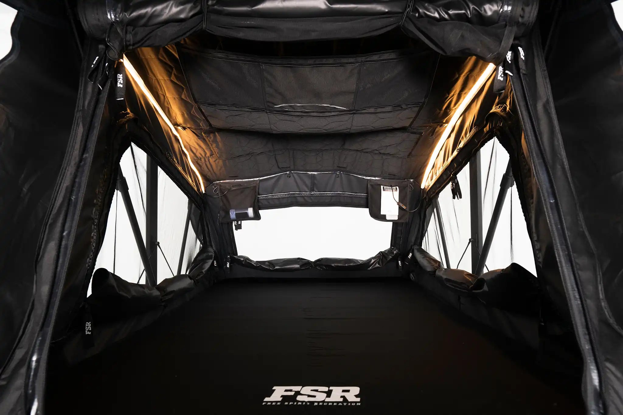 Interior photo of FSR Nova rooftop tent deployed with the interior lights on.